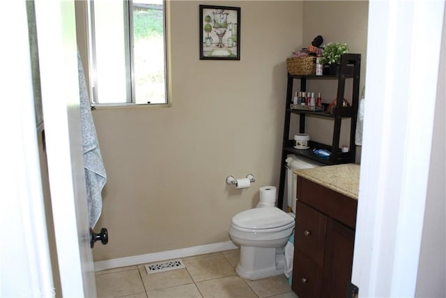 half bath featuring vanity, toilet, tile patterned floors, baseboards, and visible vents