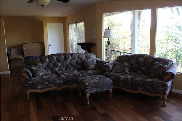 living room with baseboards, a ceiling fan, and wood finished floors