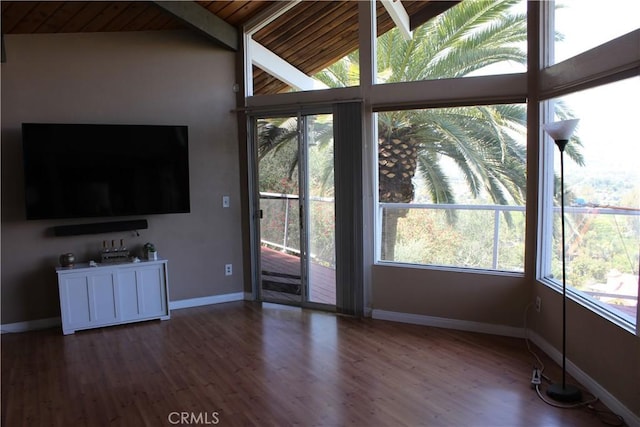 unfurnished living room with a healthy amount of sunlight, baseboards, wooden ceiling, and wood finished floors