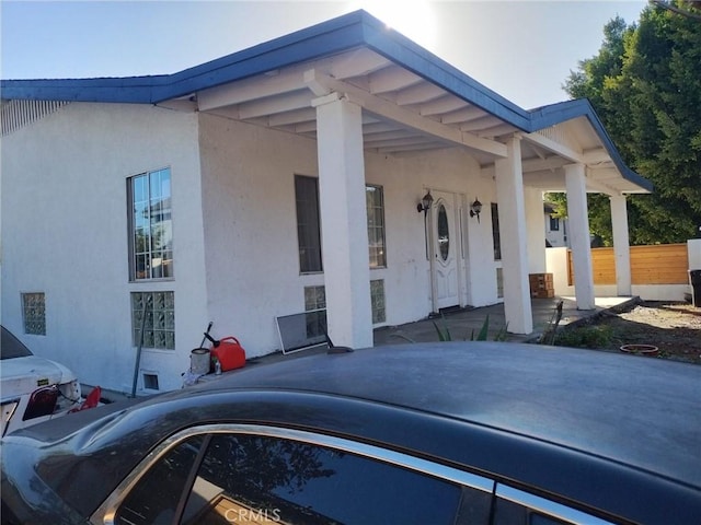 view of home's exterior with fence and stucco siding