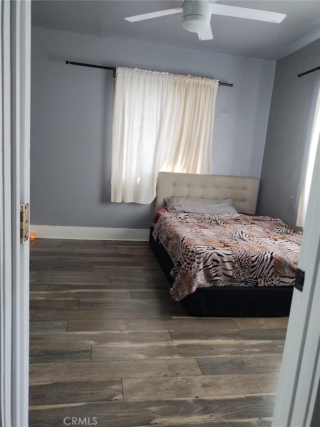 bedroom with baseboards, a ceiling fan, and hardwood / wood-style floors