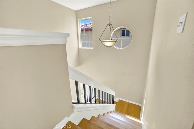 stairway with baseboards and wood finished floors