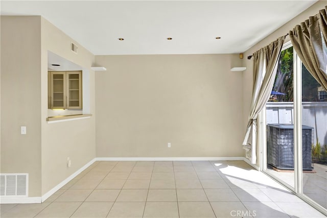 spare room with light tile patterned floors, baseboards, and visible vents