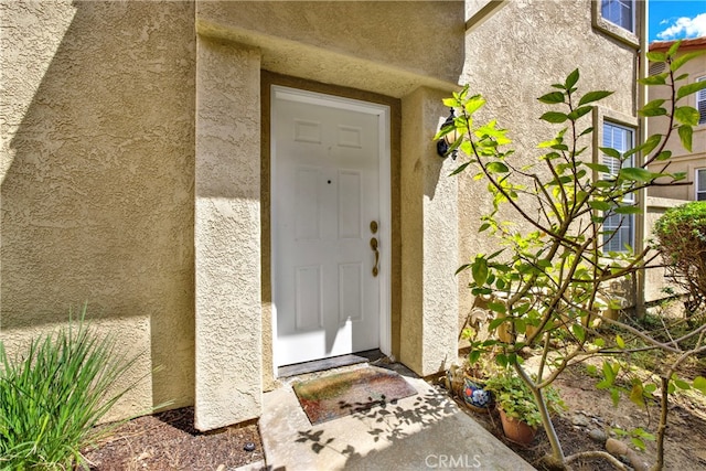 view of exterior entry featuring stucco siding