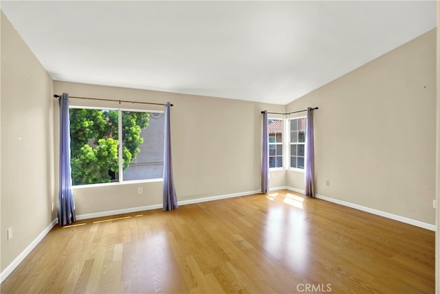 unfurnished room with baseboards and wood finished floors