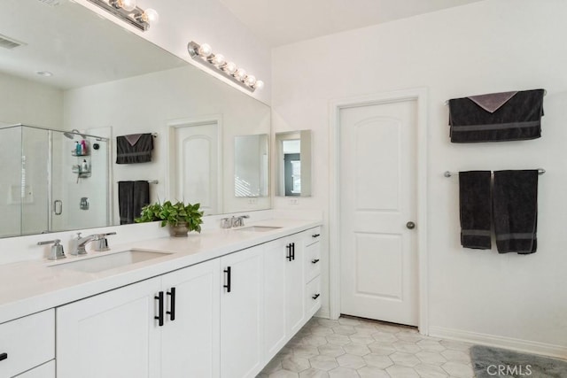 full bathroom with a sink, tile patterned floors, a stall shower, and double vanity