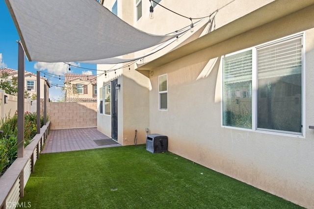 exterior space with a patio area, stucco siding, a yard, and fence