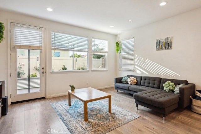 living area with recessed lighting, baseboards, and light wood-type flooring
