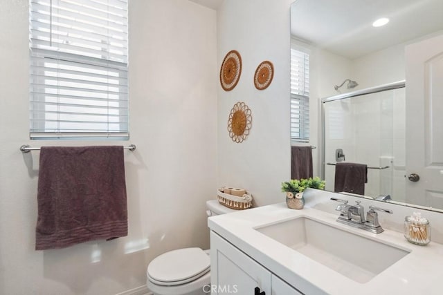 bathroom featuring vanity, a stall shower, and toilet