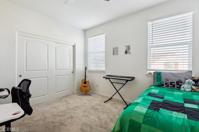 carpeted bedroom with baseboards, multiple windows, a ceiling fan, and a closet
