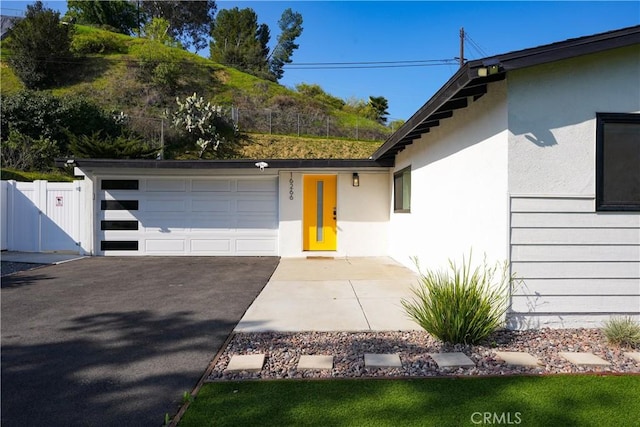 16266 Sigman St, Hacienda Heights, CA 91745 - exterior space featuring a garage, stucco siding, driveway, and fence