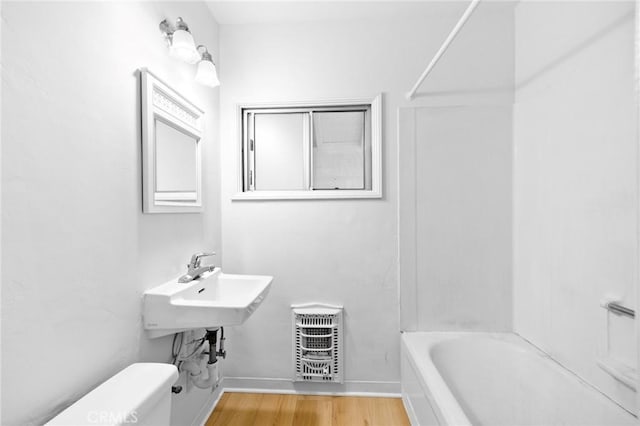 full bathroom featuring baseboards, a sink, wood finished floors, and toilet