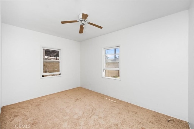 carpeted spare room with ceiling fan