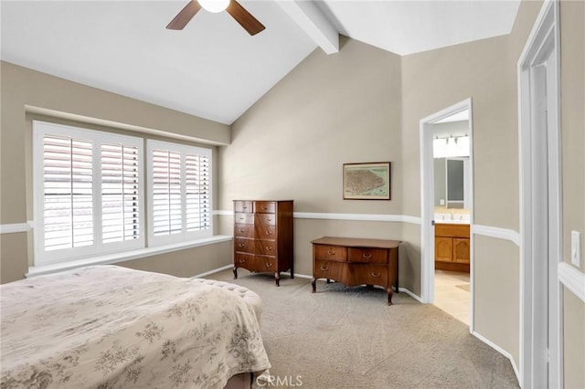 bedroom featuring baseboards, carpet flooring, lofted ceiling with beams, and ensuite bath
