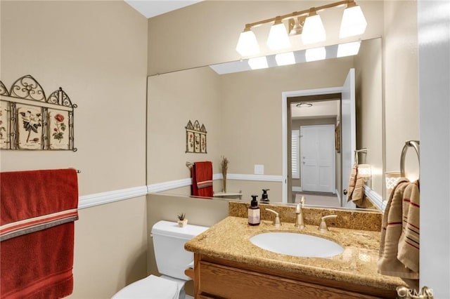 half bathroom with vanity and toilet
