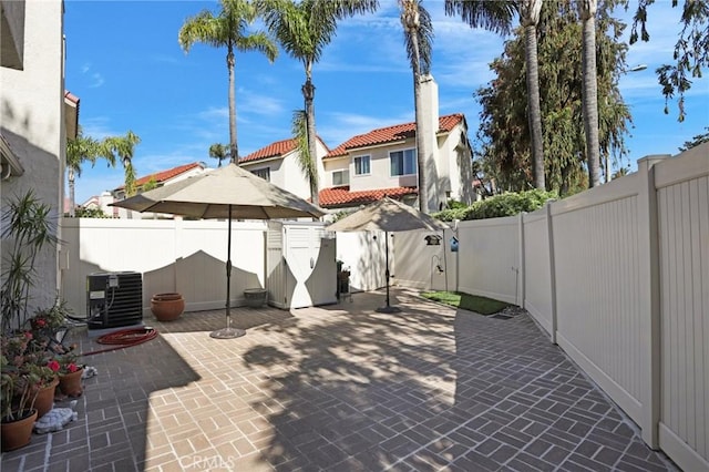 view of patio featuring a fenced backyard, a gate, and central AC unit