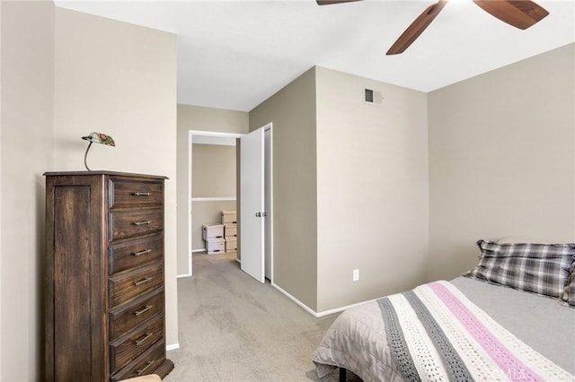 bedroom with a ceiling fan, baseboards, visible vents, and light carpet