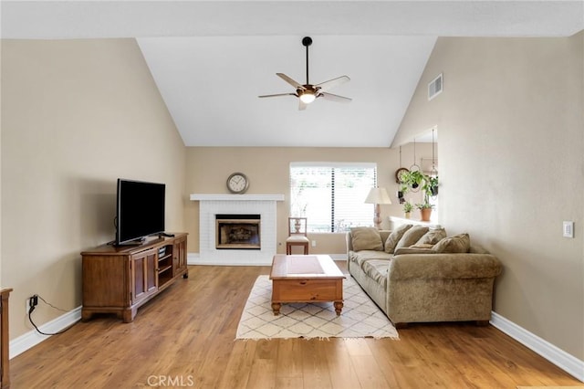 living area featuring ceiling fan, visible vents, a brick fireplace, baseboards, and light wood-style floors