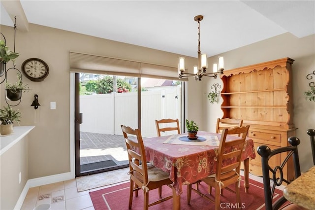 dining room featuring light tile patterned floors, baseboards, and a notable chandelier