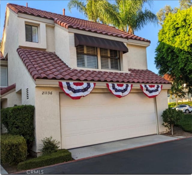 mediterranean / spanish home with stucco siding and a tile roof