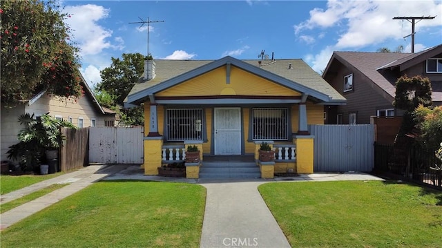 view of front of home featuring fence, a gate, and a front lawn