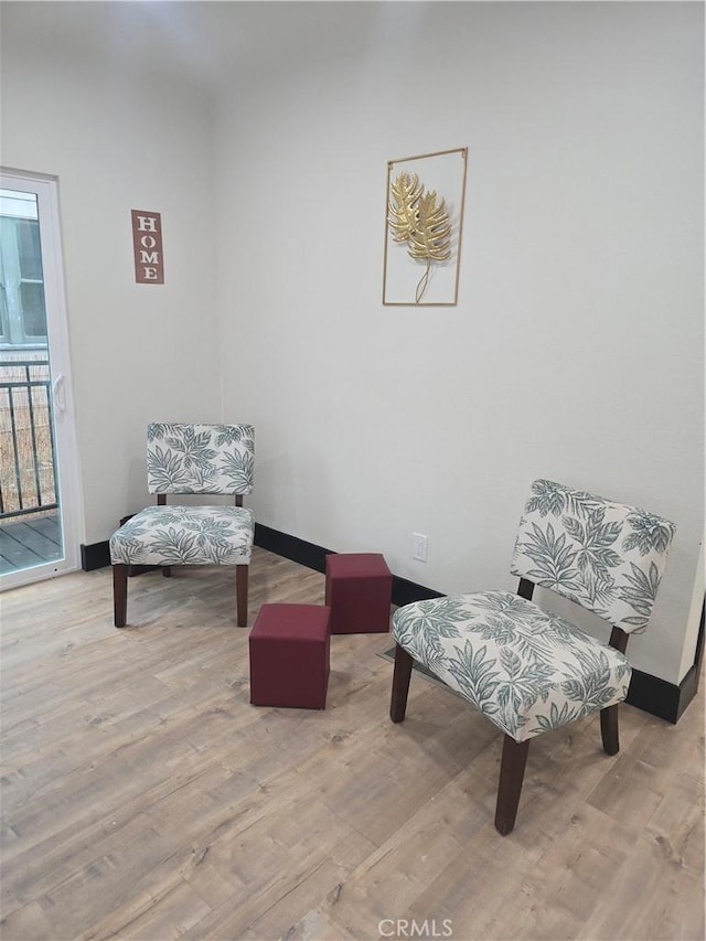 living area featuring baseboards and wood finished floors