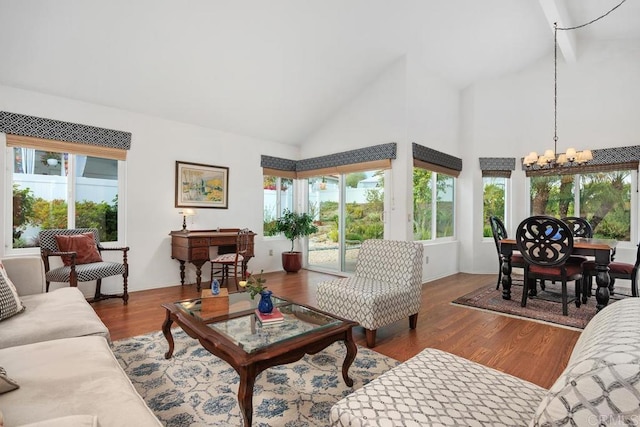 living area with an inviting chandelier, wood finished floors, and high vaulted ceiling