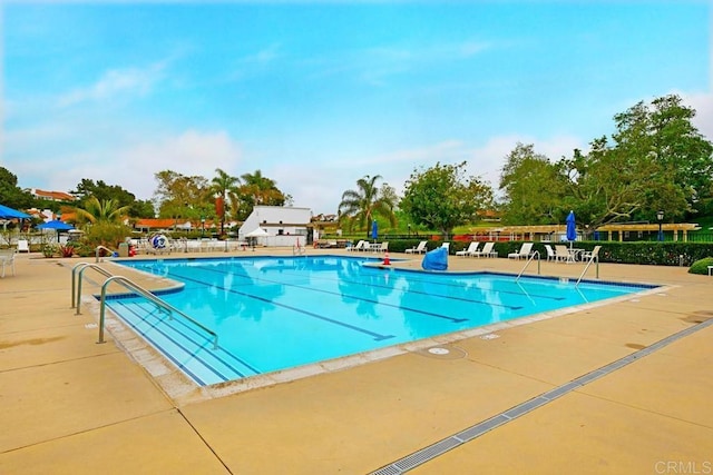 community pool with fence and a patio area