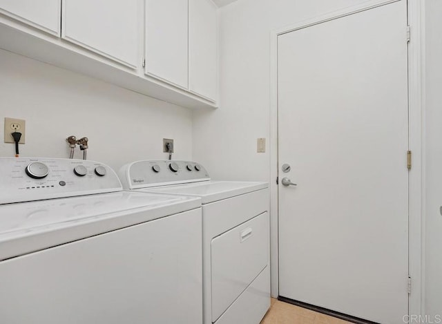 clothes washing area featuring separate washer and dryer, cabinet space, and light tile patterned flooring