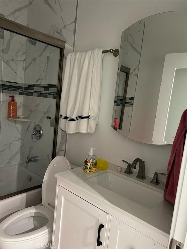 full bathroom featuring toilet, enclosed tub / shower combo, and vanity