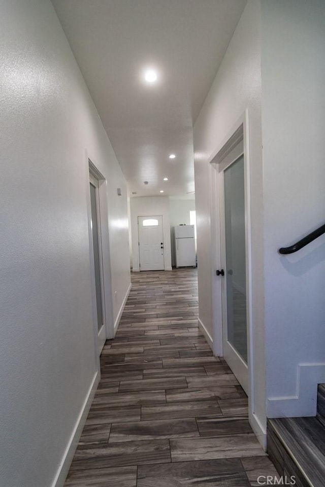 corridor with recessed lighting, baseboards, and dark wood-type flooring
