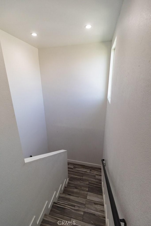 staircase with recessed lighting and wood finished floors
