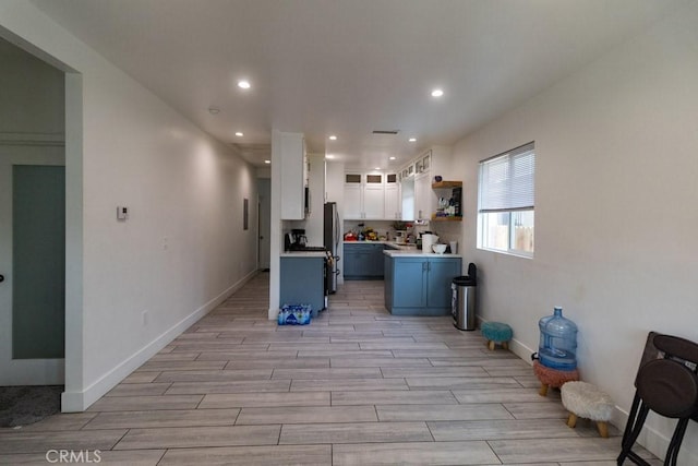 kitchen with open shelves, recessed lighting, light wood-style flooring, and white cabinetry