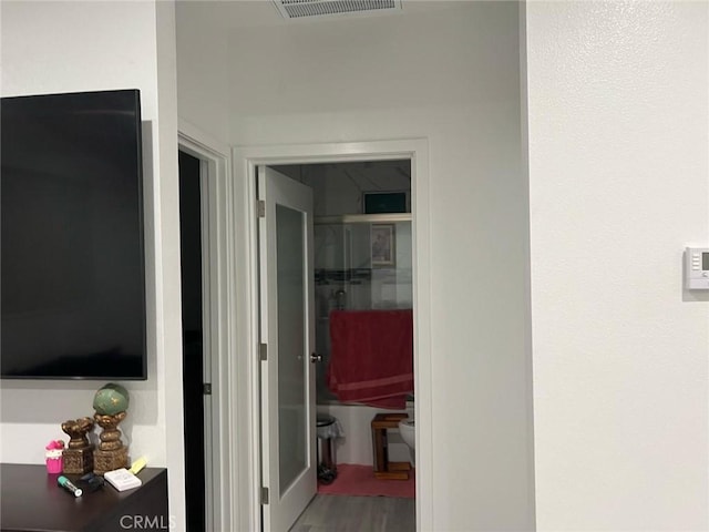 corridor featuring visible vents and wood finished floors