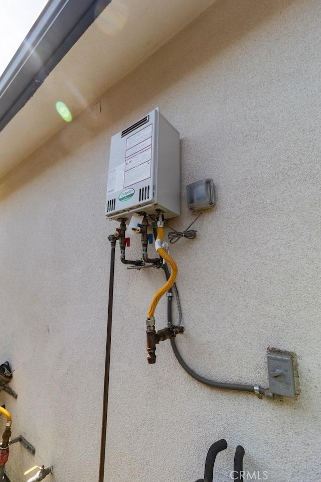 details featuring water heater and stucco siding