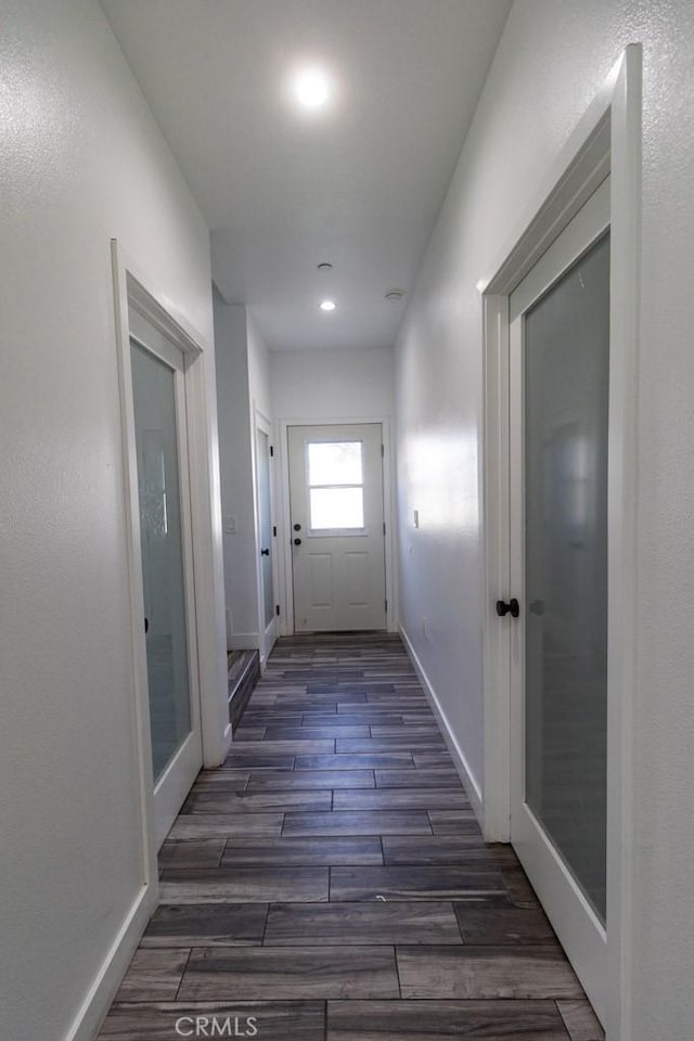corridor with dark wood-style flooring, baseboards, recessed lighting, and french doors