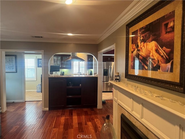 interior space with baseboards, ornamental molding, dark wood-style flooring, and visible vents