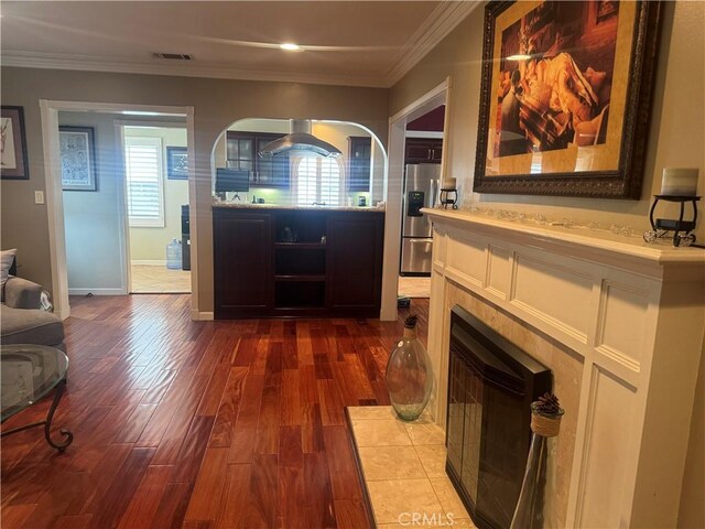 living room with baseboards, dark wood finished floors, ornamental molding, and visible vents