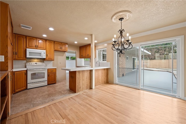 5449 E Fairbrook St, Long Beach, CA 90815 - kitchen with visible vents, white appliances, light countertops, brown cabinets, and a notable chandelier