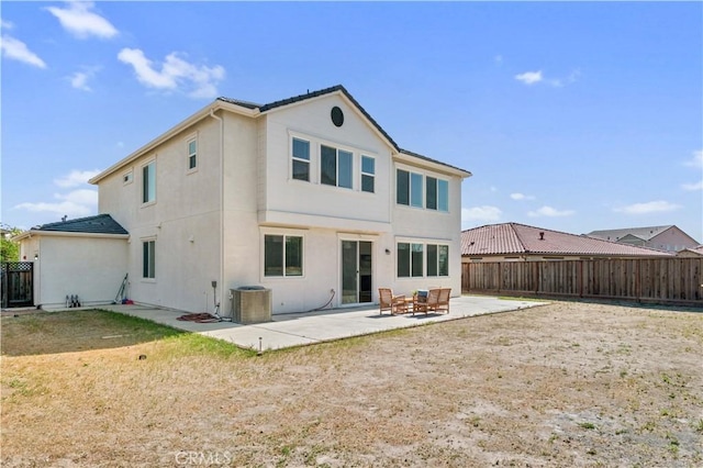 back of house featuring central AC, a fenced backyard, a patio area, and stucco siding