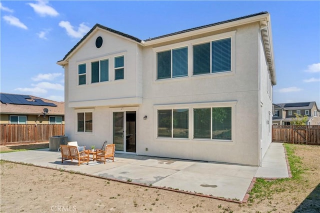back of house with a patio, central AC unit, a fenced backyard, and stucco siding