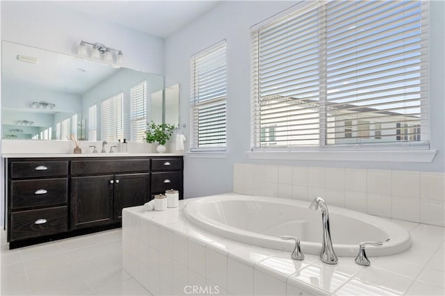 bathroom with a garden tub, tile patterned flooring, and vanity