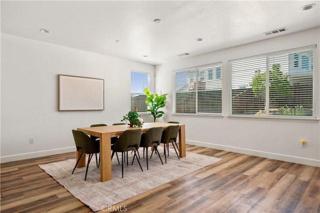 dining room with visible vents, baseboards, and wood finished floors