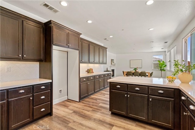 kitchen featuring light wood-style floors, light countertops, dark brown cabinets, and visible vents