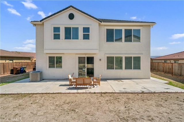 rear view of house featuring a fenced backyard, stucco siding, a patio area, and central AC