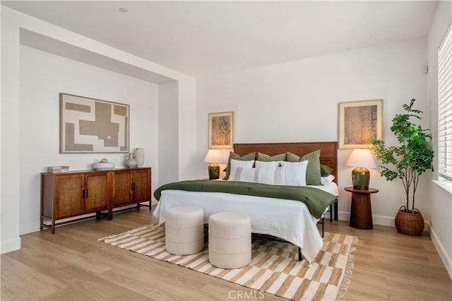 bedroom with baseboards and light wood-style flooring