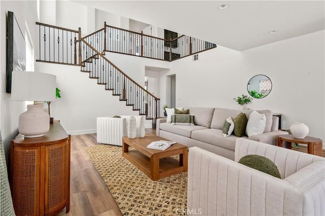 living area featuring recessed lighting, baseboards, wood finished floors, visible vents, and stairway