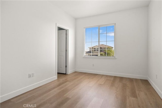 unfurnished room featuring baseboards and light wood-style floors