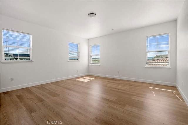 spare room with light wood-style floors and baseboards