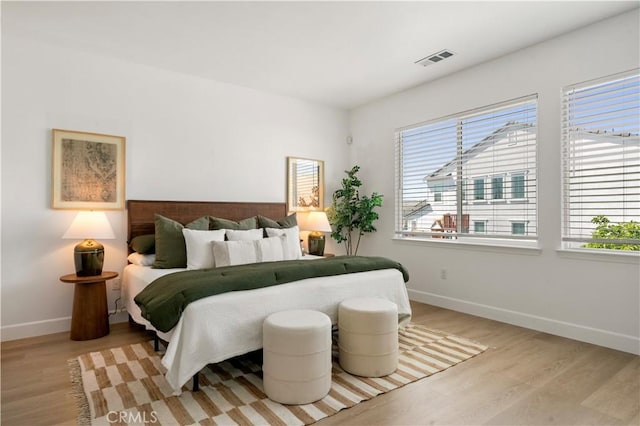 bedroom with visible vents, baseboards, and light wood-type flooring